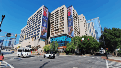 The Center (former CNN Center) under renovation, with cranes, digital billboards, and new public plazas in vibrant downtown Atlanta