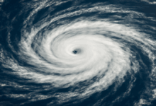 A swirling hurricane with a well-defined eye seen from space, representing Hurricane Erin over the Atlantic Ocean.