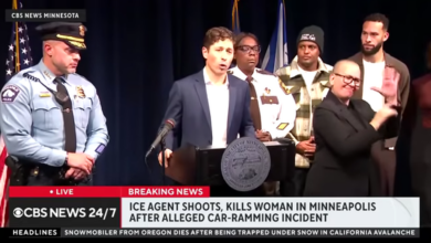 A televised press conference shows Minneapolis city officials at a podium as local law enforcement and community members stand behind, with a news chyron reporting that an ICE agent shot and killed a woman in an alleged car‑ramming incident in Minneapolis.